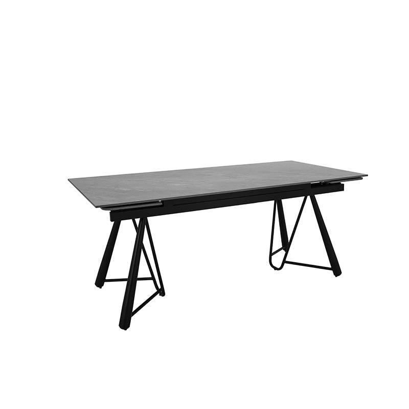 Mesa de comedor extensible Yad de color gris oscuro con superficie de cerámica y base de pedestal metálico, vista frontal.