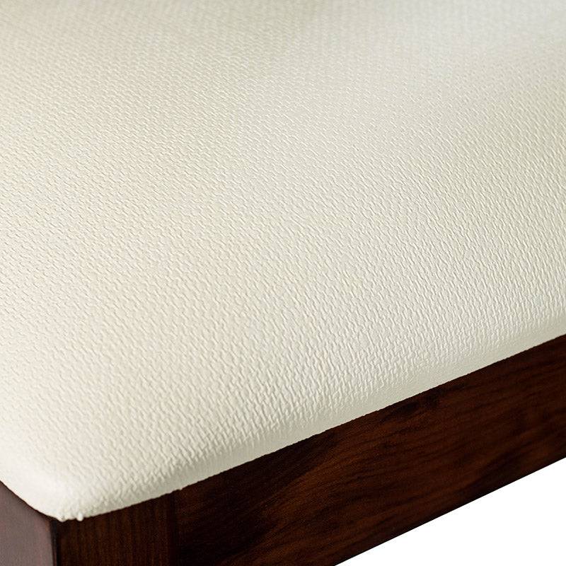 Juego de comedor Quetzal de nueve piezas con sillas en madera de pino enchapada en caoba y tapizado en leather touch.