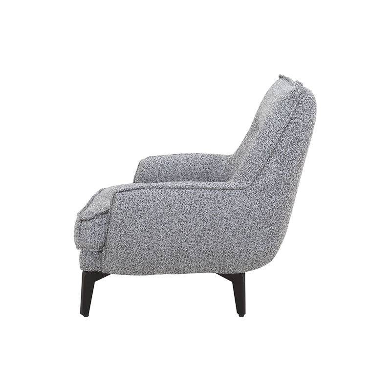 Sillón Andrea Berlin de tapiz gris, con respaldo y asiento acolchados, en interior moderno.